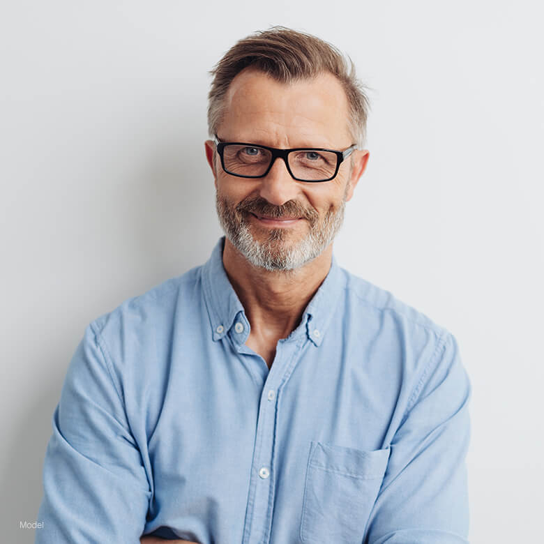 Mature man with glasses in a blue shirt